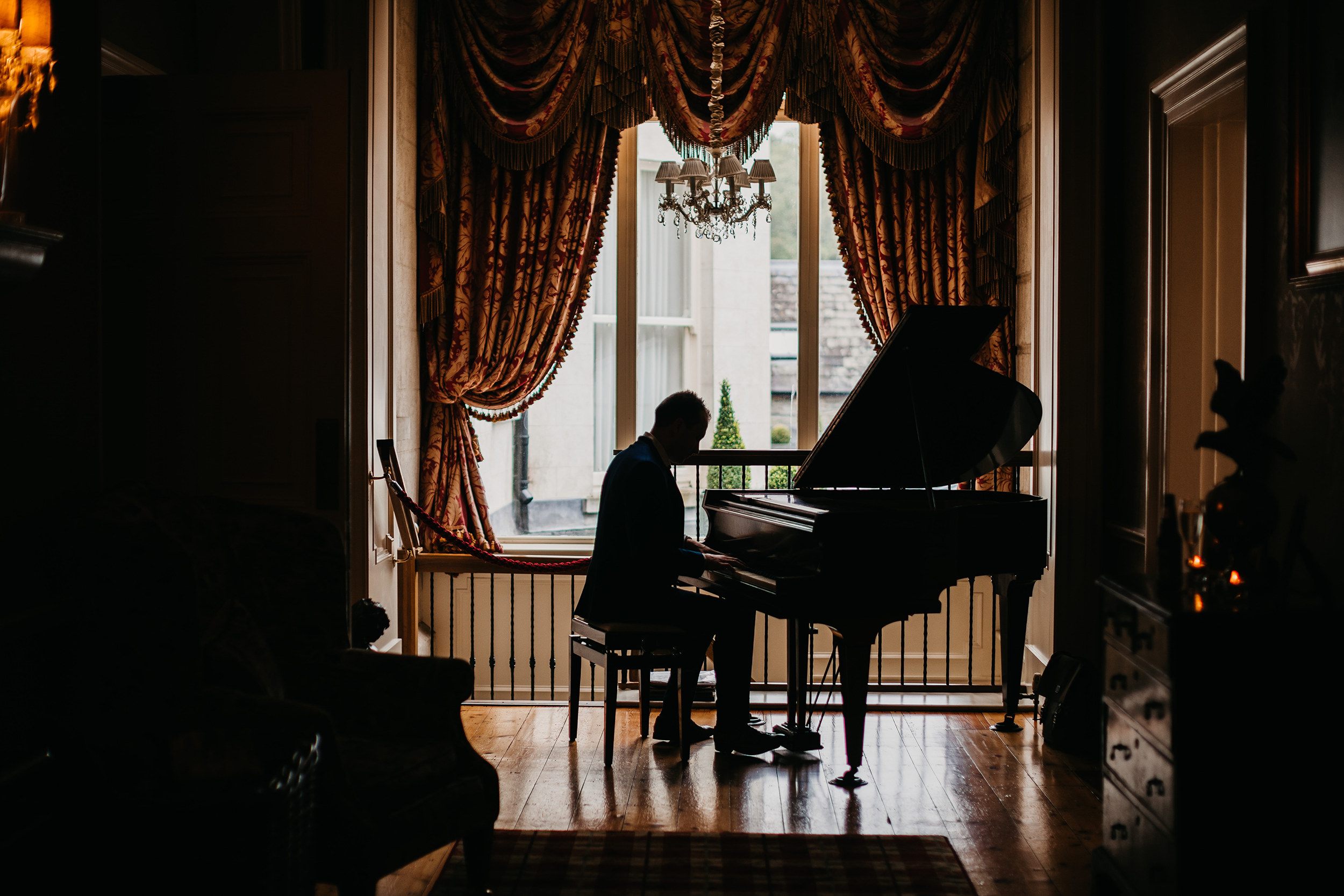 Silhouette of Joe Kenny playing baby grand piano in Tankardstown House, Co. Meath