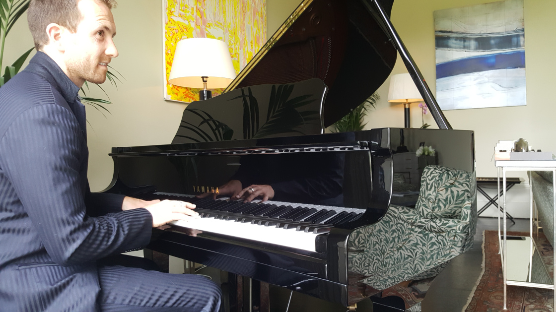 Joe Kenny playing grand piano at wedding drinks reception in Virginia Park Lodge, Co. Cavan